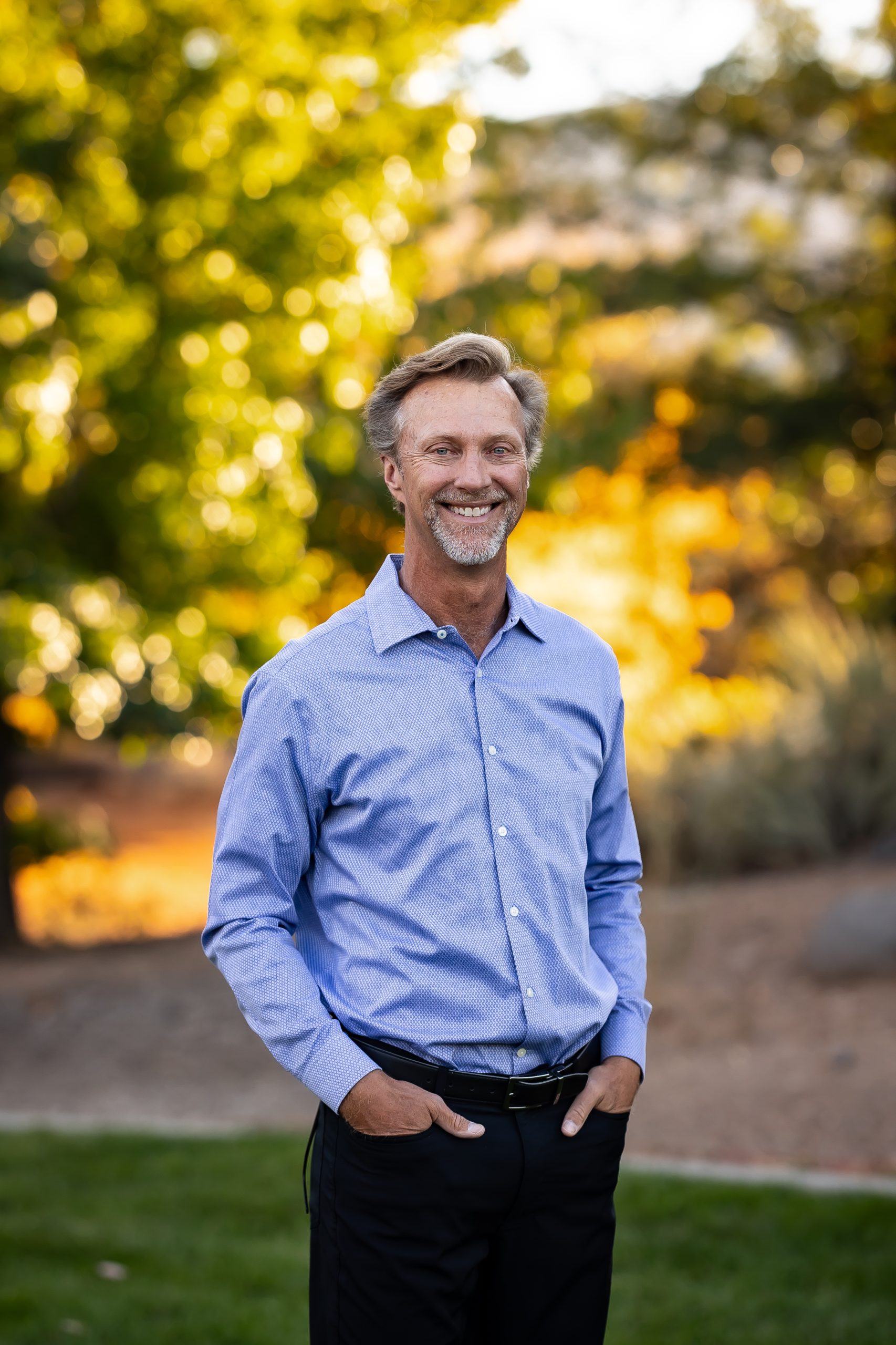 Dr. Kevin, a Reno orthodontist is posing with his hands in his pockets while smiling