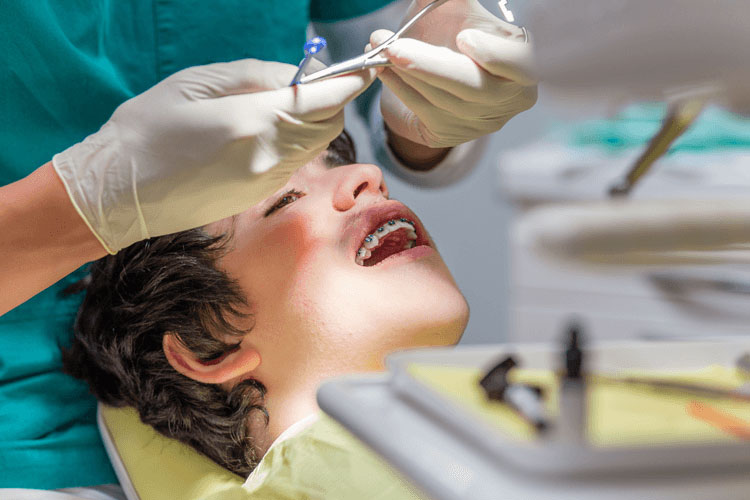 Doctor adjusting teen's Braces